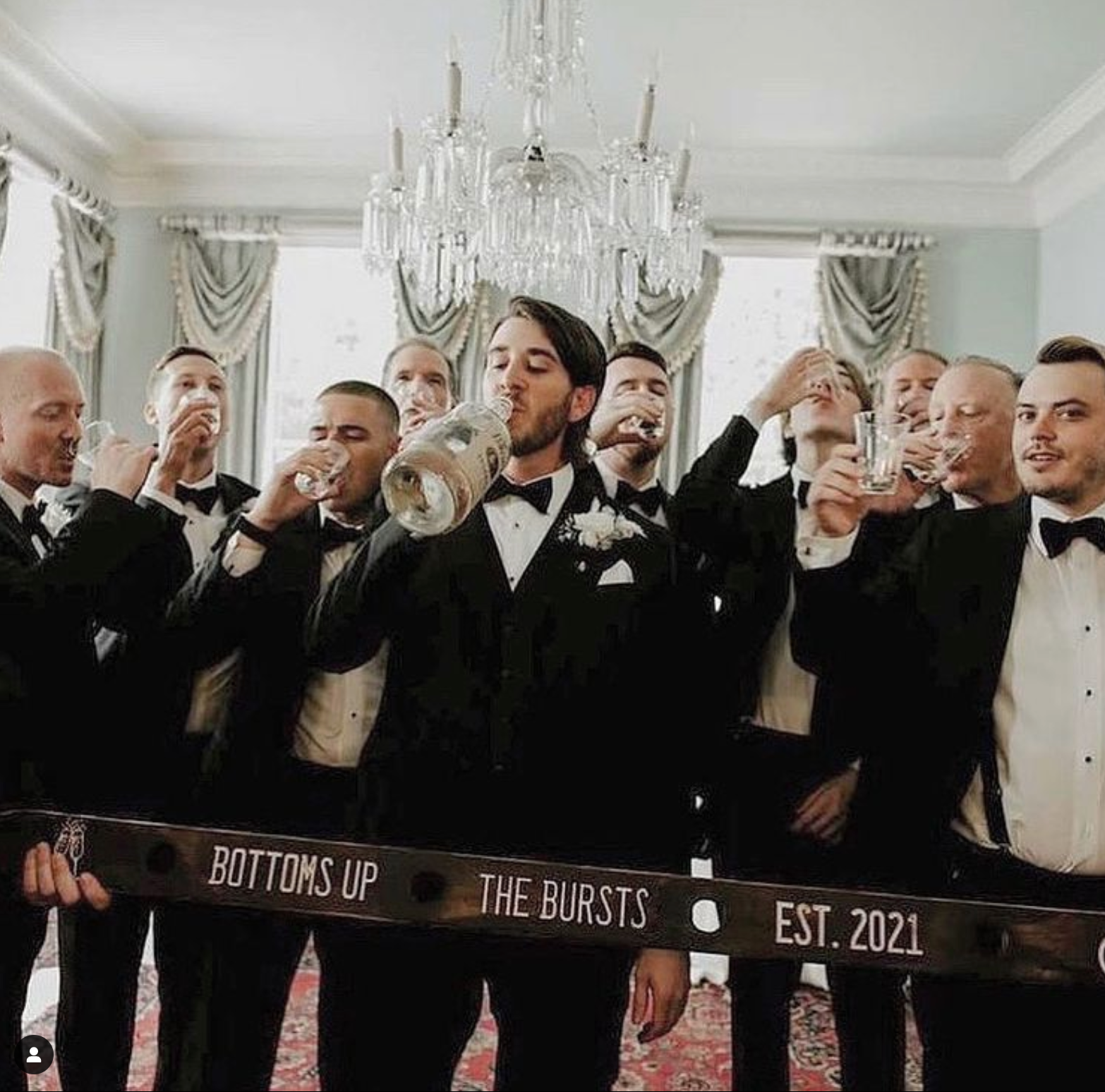 groom and wedding party drinking from a shot ski